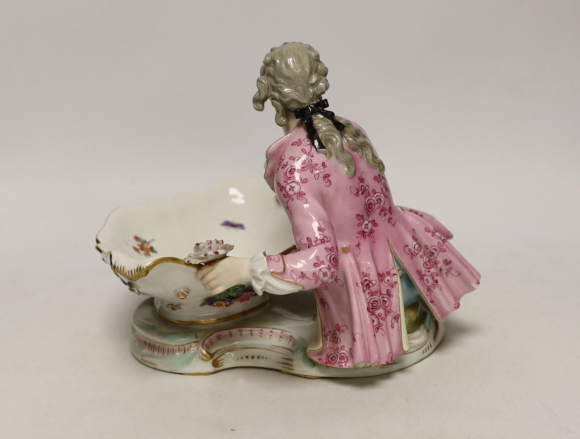 A 19th century Meissen figural sweetmeat dish with floral encrusted decoration, crossed swords mark to the base, 30cm wide